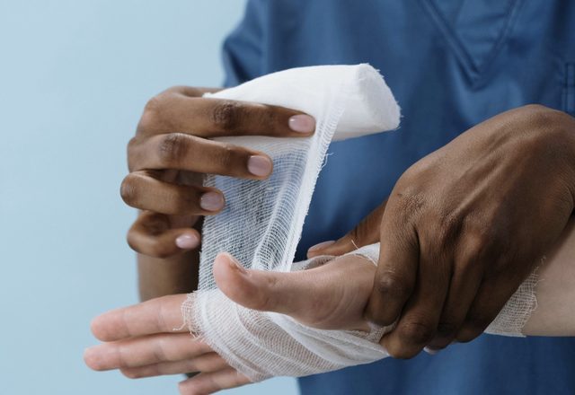 Clinician wrapping a patient's injured hand